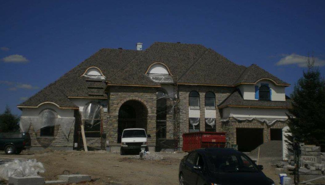 A large stone house with a new shingle roof