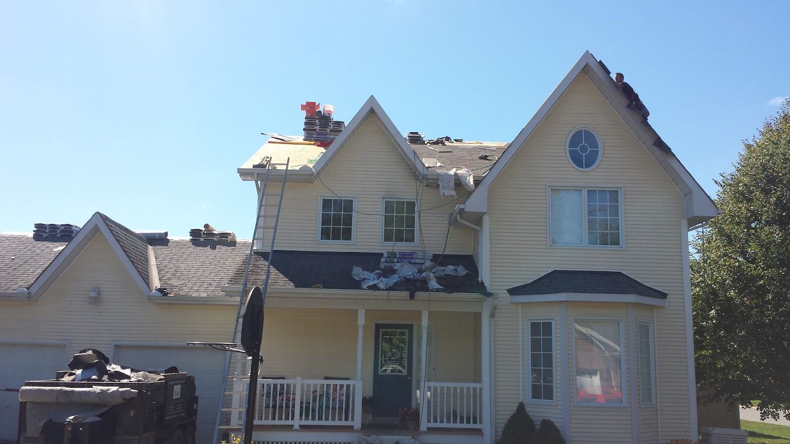 A yellow two-storey Victorian house partway through a re-roof